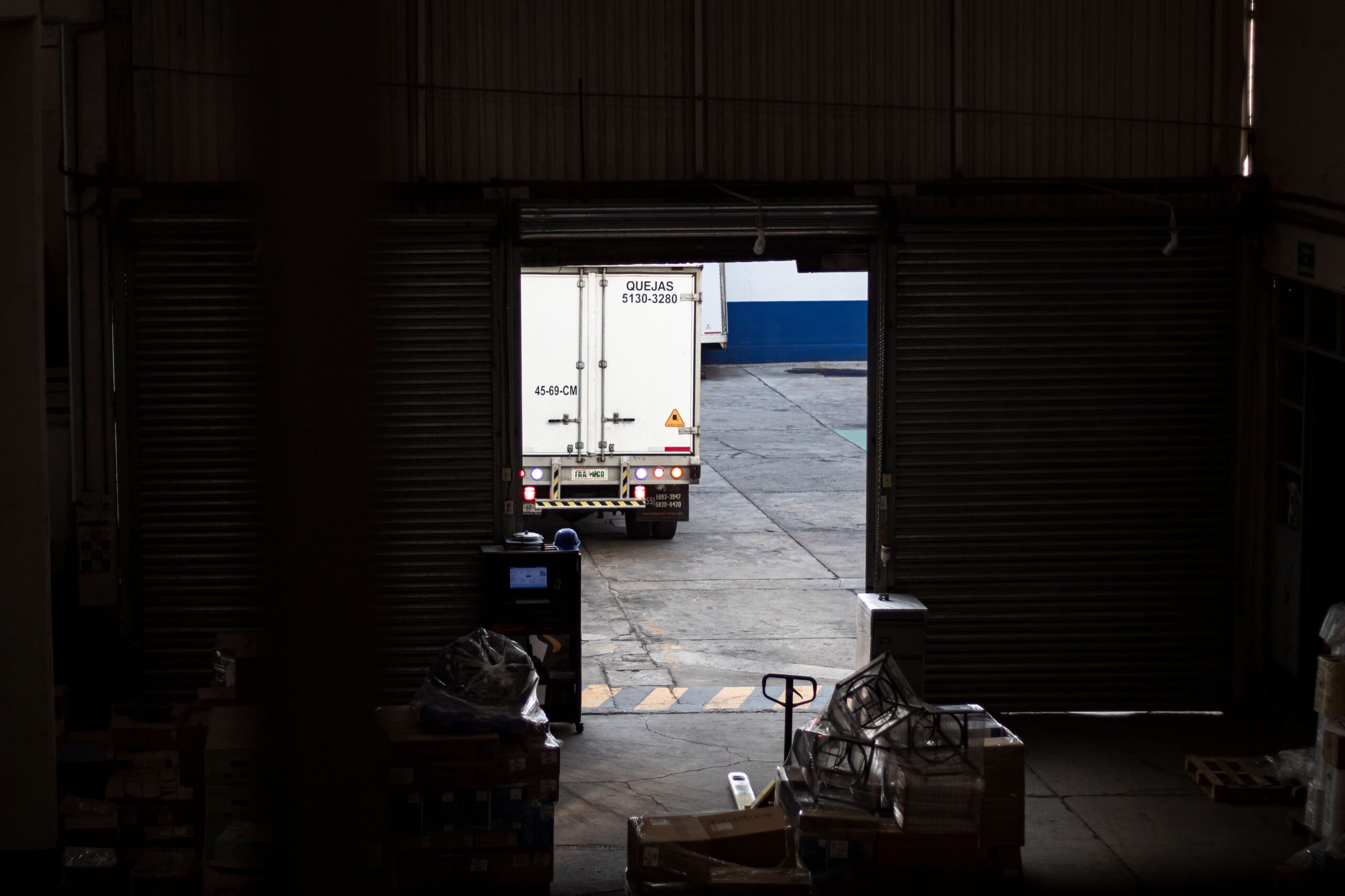 White delivery truck exiting a warehouse loading dock